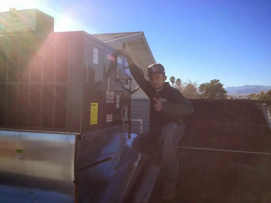 HVAC technician performing Heat Pump Repair on a rooftop unit in Savage